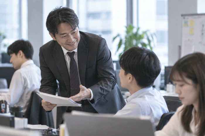 部下に指示しながら顔色をうかがう40代の上司